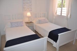 马尔德·克里斯塔尔Albatros Playa 2 - 9408的白色卧室配有两张床和一盏灯