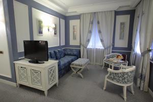 那不勒斯帕拉索阿拉巴迪耶里酒店的客厅配有蓝色的沙发和电视
