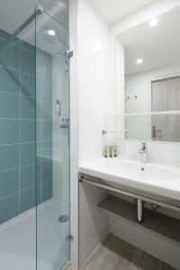 巴拉吕克莱班奥佩拉里亚派斯酒店的一间带水槽和玻璃淋浴的浴室