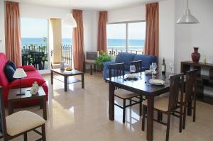 托罗克斯科斯塔欧马尔海滩公寓的一间带桌椅和海洋的客厅