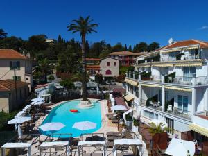 费拉角圣让Boutique Hotel & Spa la Villa Cap Ferrat的一个带游泳池、椅子和棕榈树的度假村