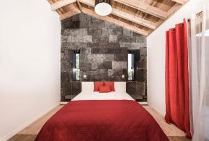 圣罗克杜皮库Vila Verde的一间卧室配有一张红床和砖墙
