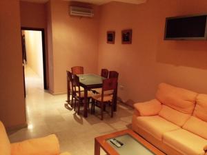 桑卢卡尔-德巴拉梅达多纳拿公寓式酒店的客厅配有桌子和沙发