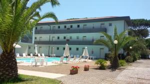 普林希匹纳马尔Residence Verde Pineta的一座拥有游泳池和棕榈树的酒店