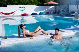里乔内Love Boat Hotel - The Original的坐在游泳池里的男人和女人