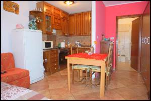 萨武德里亚Apartments Nives NB的厨房配有一张桌子,上面有红色的桌布