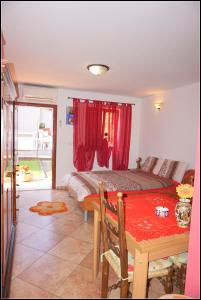 萨武德里亚Apartments Nives NB的一间卧室配有一张床和一张带红色窗帘的桌子