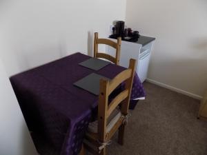普里茅斯A Home From Home 2的一张桌子,一张桌子,上面有紫色的桌布和两把椅子