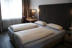 杜塞尔多夫地铁酒店的一间卧室配有两张带白色枕头的床