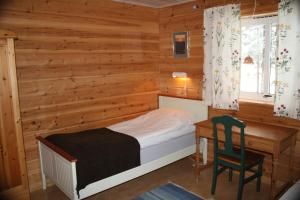 Kvikkjokks KapellÅrrenjarka Mountain Lodge的一间卧室配有一张床、一张桌子和一把椅子