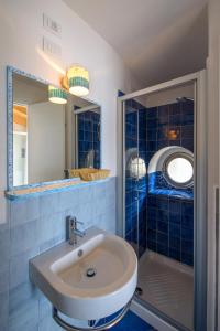 康培斯Le poste di Simplicio的蓝色瓷砖浴室设有水槽和淋浴
