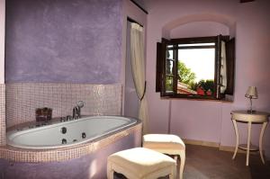 恩波利博尔戈圣朱斯托酒店的带浴缸、桌子和窗户的浴室
