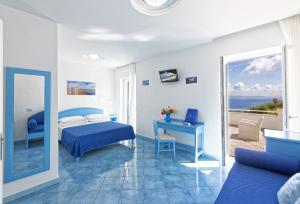 伊斯基亚维拉道尔塔酒店的一间卧室配有一张床、一张书桌和一个窗户。