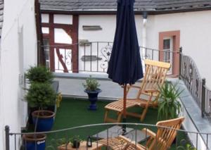 贝尔恩卡斯特尔-库斯Märchenhotel的庭院设有椅子、雨伞和盆栽植物