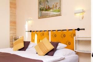 巴拉通尤洛克Albergo Giardino的一间卧室配有一张黄色床头板的床