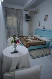 马赫迪耶Houria House Sable D'or的一间设有一张床和一张花瓶桌子的房间