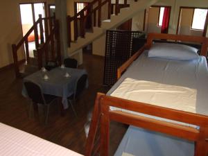 康提城市中心旅舍的客房设有两张床、一张桌子和楼梯。