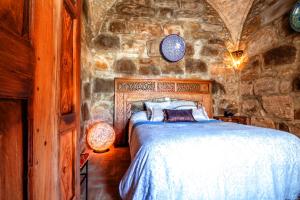 塔里法艾尔阿斯图里亚斯酒店的卧室配有一张石墙床