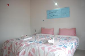Torres de AlbarracínApartamentos La Harinera的卧室配有一张带粉红色枕头的大床