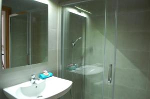 Torres de AlbarracínApartamentos La Harinera的带淋浴、盥洗盆和镜子的浴室