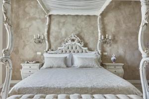 明乔河畔蓬蒂La Zarabba Boutique Hotel的卧室配有白色的天蓬床和白色的家具