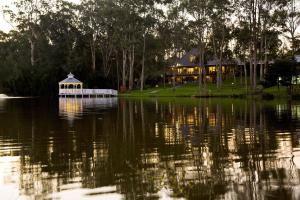 巴特曼斯贝Lincoln Downs Resort Batemans Bay的湖中带凉亭的房子