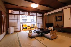 丰冈市斯诺梅索酒店的客厅配有桌椅和窗户。