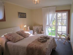 基督城Magnolia Cottage的一间卧室配有一张床,上面有两条毛巾