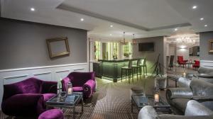 戛纳德拉图尔城堡酒店的一间客厅,配有紫色家具和酒吧