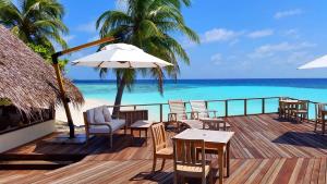 Makunudhoo马库努都岛的一个带桌椅和遮阳伞的甲板和大海