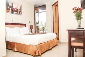 亚的斯亚贝巴轻松住宿酒店的一间卧室配有一张大床和一张桌子