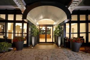 滨海托萨金色之海蒙努达酒店的植物盆栽建筑的入口