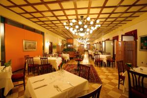 卡奥莱多吉别墅酒店的餐厅配有白色的桌椅和吊灯