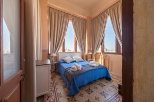 加利波利瓦莱博纳宫住宿加早餐旅馆的一间卧室配有一张带蓝色床单和窗户的床。