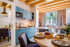 赫瓦尔Heritage suites Zanini的厨房配有蓝色橱柜和一张带食物的桌子