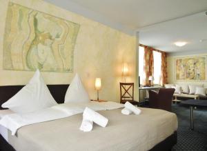 奥斯赛拜-屈隆斯博恩奥斯特埃斯图恩酒店的酒店客房配有一张带白色枕头的大床