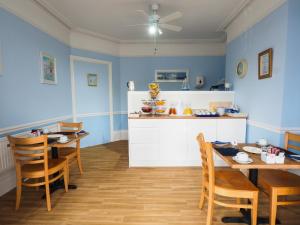 伊斯特布恩海湾居所宾馆的厨房拥有蓝色的墙壁和木制桌椅