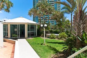黄金海岸海冲浪海滨度假公寓酒店的一座种有棕榈树的花园及一座建筑
