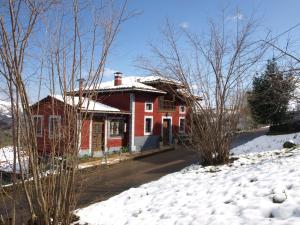博比亚达里巴Casa Rural Alborada的一座红色的房子,地面上积雪