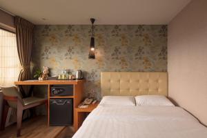 台北悠趣旅店的一间卧室配有一张床和一张书桌