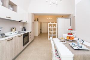莫诺波利Casa Velia的厨房配有桌子和白色冰箱。