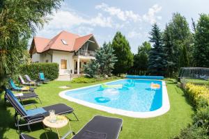 扎马迪Villa Oliva Boutique Rooms & Spa Zamárdi的后院设有游泳池、椅子和房屋