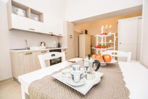 莫诺波利Casa Velia的厨房以及带白色桌椅的用餐室。