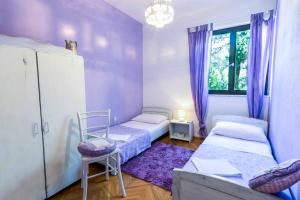 苏佩塔尔Apartment Dunja的客房设有两张床和一个带紫色窗帘的窗户。