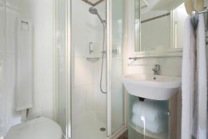 巴黎巴黎巴斯特尔酒店的白色的浴室设有水槽和淋浴。