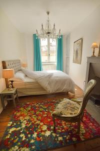 勒布伊Les Apparts du Plot的一间卧室配有一张床、一把椅子和地毯