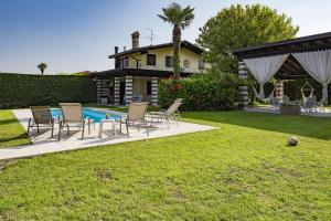 巴多利诺Villa Costabella的后院设有游泳池、椅子和房屋
