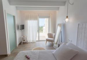 费雷列斯桑比韦斯梅诺卡旅馆 - 仅限成人入住的卧室配有床、椅子和窗户。