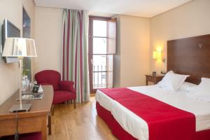 卡塞雷斯唐费尔南多索霍精品酒店的酒店客房,配有一张床和一张红色椅子