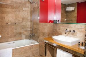 卡塞雷斯唐费尔南多索霍精品酒店的一间带水槽、浴缸和淋浴的浴室